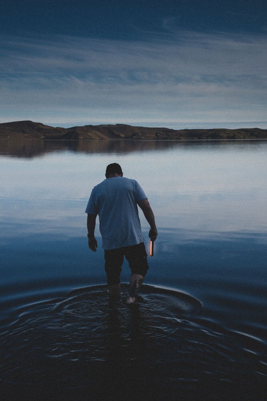 Felipe García del Río walking into a lake in Iceland at dusk